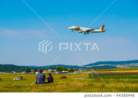 Father and son watching landing airplanes at Zurich airport at sunny day time Father and son watching landing airplanes at Zurich airport at sunny day time 44388446