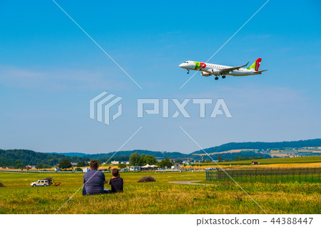 Father and son watching landing airplanes at Zurich airport at sunny day time Father and son watching landing airplanes at Zurich airport at sunny day time 44388447