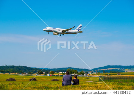 Father and son watching landing airplanes at Zurich airport at sunny day time 44388452