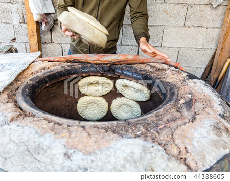 Traditional Uzbek flatbread baking in the tandyr Traditional Uzbek flatbread baking in the tandyr 44388605