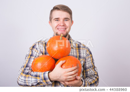 portrait of a young farmer holding a pumpkins on white background portrait of a young farmer holding a pumpkins on white background 44388960