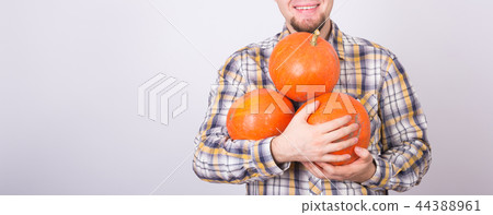 Close up of male farmer with pumpkins smiling over the white background with copy space Close up of male farmer with pumpkins smiling over the white background with copy space 44388961