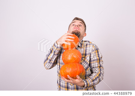 People, holidays and autumn concept - young man carrying pumpkins on white background with copy People, holidays and autumn concept - young man carrying pumpkins on white background with copy 44388979