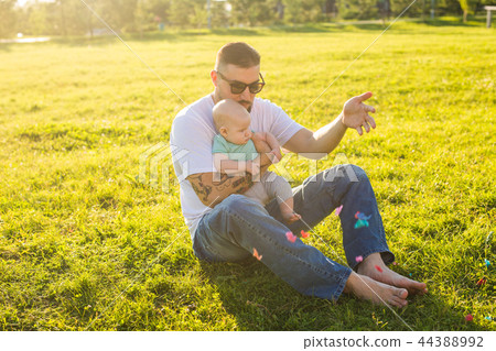Happy father holding baby son on nature. Concept of happy family, father's day and child. 44388992