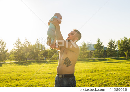 Happy father holding baby son, throwing baby in air. Concept of happy family, father's day and child Happy father holding baby son, throwing baby in air. Concept of happy family, father's day and child 44389016