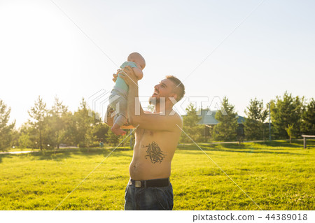 Happy father holding baby son, throwing baby in air. Concept of happy family, father's day and child 44389018