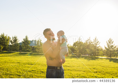 Happy father holding baby son on nature. Concept of happy family, father's day and child. Happy father holding baby son on nature. Concept of happy family, father's day and child. 44389136