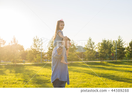 Fatherhood, family and children concept - Father and daughter having fun and playing in nature. Fatherhood, family and children concept - Father and daughter having fun and playing in nature. 44389288