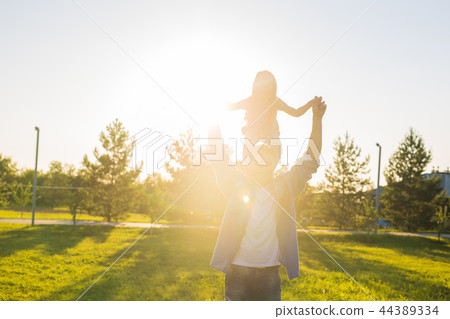 Fatherhood, family and children concept - Father and daughter having fun and playing in nature. Fatherhood, family and children concept - Father and daughter having fun and playing in nature. 44389334
