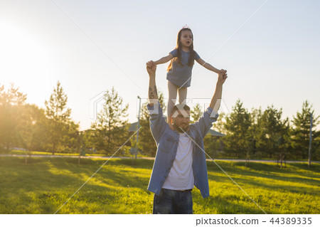 Fatherhood, family and children concept - Father and daughter having fun and playing in nature. Fatherhood, family and children concept - Father and daughter having fun and playing in nature. 44389335