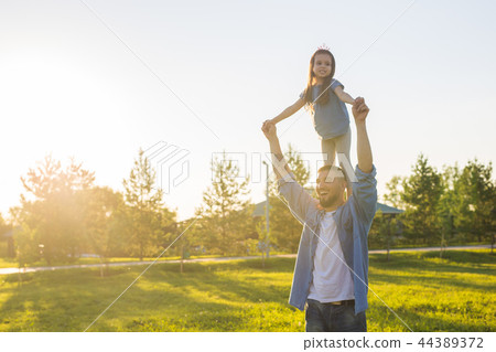 Fatherhood, family and children concept - Father and daughter having fun and playing in nature. 44389372