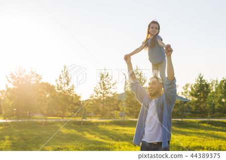 Fatherhood, family and children concept - Father and daughter having fun and playing in nature. Fatherhood, family and children concept - Father and daughter having fun and playing in nature. 44389375