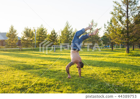 Yoga, fitness and healthy lifestyle concept - man doing a handstand on summer nature 44389753