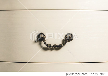 Close-up element of the drawer in the cabinet with a metal handle and wooden patterns. Detail of new Close-up element of the drawer in the cabinet with a metal handle and wooden patterns. Detail of new 44391986