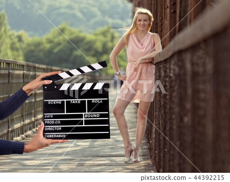 Clapperboard sign hold by female hands. 44392215