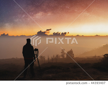 Traveller taking photograph of landscape 44393407