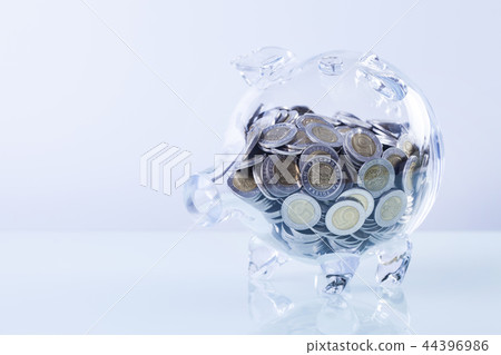 Glass piggy bank with coins inside Glass piggy bank with coins inside 44396986