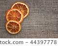 Dried orange slices on jute background, top view 44397778