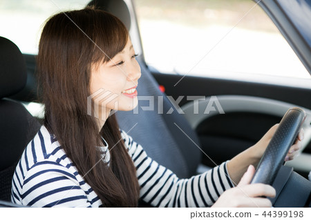 A woman driving a car 44399198