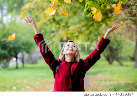 Young style girl with leaves in park alley 44399394