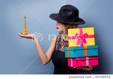 girl in black dress and hat with gifts 44399478