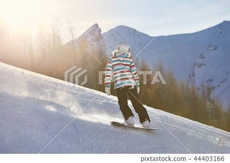 Female snowboarder in sun flare 44403166