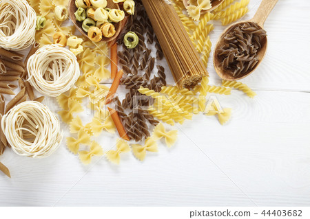 A set of raw pasta on a wooden table 44403682