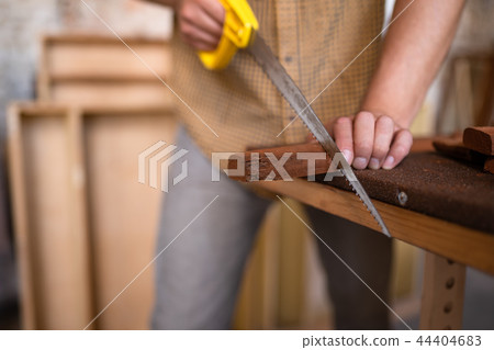 Close-up view of a joiner sawing wood 44404683