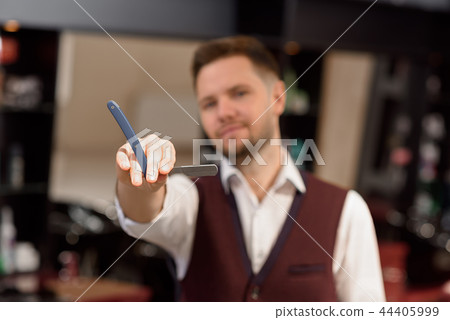 Close up of barber's hand holding razor. Close up of barber's hand holding razor. 44405999