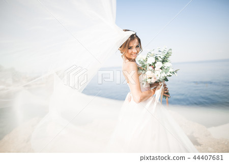 Lovely bride in white wedding dress posing near the sea with beautiful background Lovely bride in white wedding dress posing near the sea with beautiful background 44407681