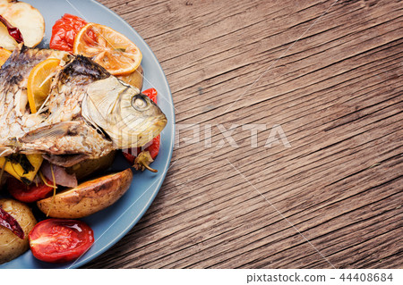 Fish baked with vegetable garnish Fish baked with vegetable garnish 44408684