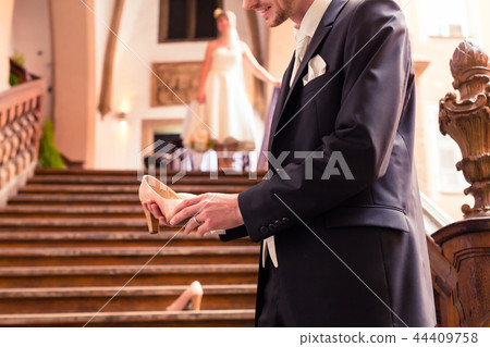 Smiling bridegroom holding high heel in his hand 44409758