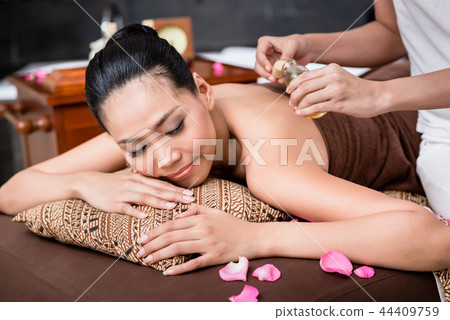 Woman receiving back massage 44409759