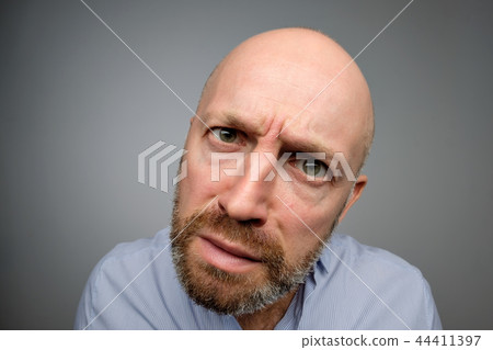 Bald mature guy in gray casual shirt discovering hidden camera. Bald mature guy in gray casual shirt discovering hidden camera. 44411397