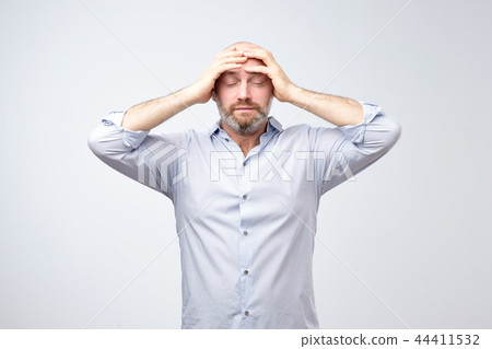 Studio portrait of upset worried sad, depressed, tired man with a headache and very stressed face 44411532