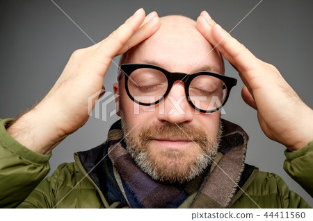 Portrait of bald adult man with beard toching his head with fingers. He is calm and content Portrait of bald adult man with beard toching his head with fingers. He is calm and content 44411560