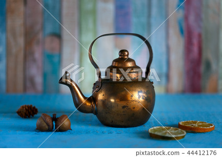 Copper kettle on wooden background Copper kettle on wooden background 44412176