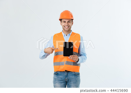 Happy young construction workers in hard hats on a white background. Happy young construction workers in hard hats on a white background. 44415690