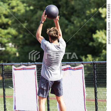 athlete throwing medicine ball over head 44416695