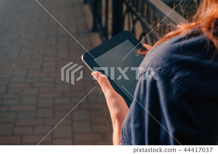Girl with tablet computer or e-reader over the shoulder view Girl with tablet computer or e-reader over the shoulder view 44417037