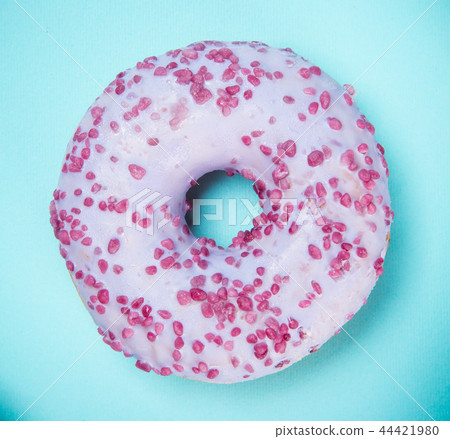 Glazed donut with colorful sprinkles on blue pastel background. Glazed donut with colorful sprinkles on blue pastel background. 44421980
