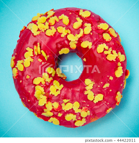Glazed donut with colorful sprinkles on blue pastel background. Glazed donut with colorful sprinkles on blue pastel background. 44422011