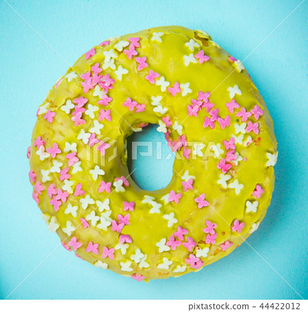 Glazed donut with colorful sprinkles on blue pastel background. Glazed donut with colorful sprinkles on blue pastel background. 44422012