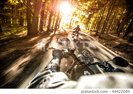 Man seat on the motorcycle on the forest road. 44422080
