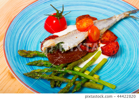 Baked poutassou with dried tomatoes, asparagus and creamy garlic sauce 44422820