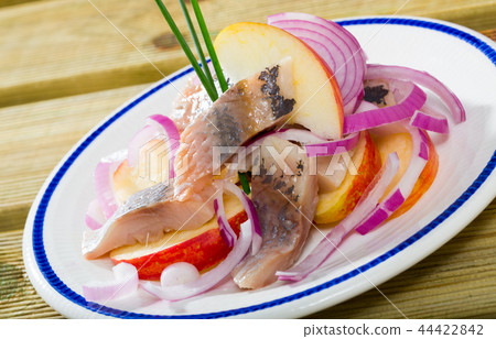 Slices of mild-cured herring with fried potatoes and onions served Slices of mild-cured herring with fried potatoes and onions served 44422842