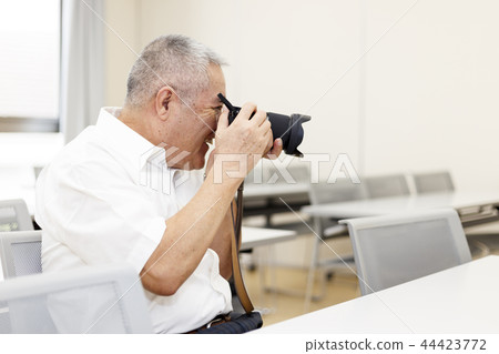 Elderly man with a camera 44423772