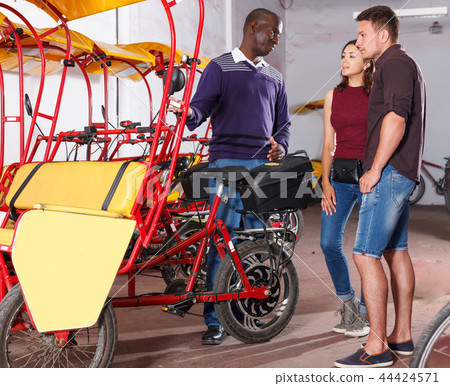 Adult tourist couple planning to hire velotaxi Adult tourist couple planning to hire velotaxi 44424571