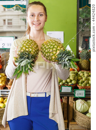 Portrait of woman who is holding pineapples 44424820