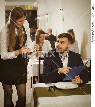 Woman waiter is taking order from client in restaurante Woman waiter is taking order from client in restaurante 44425012